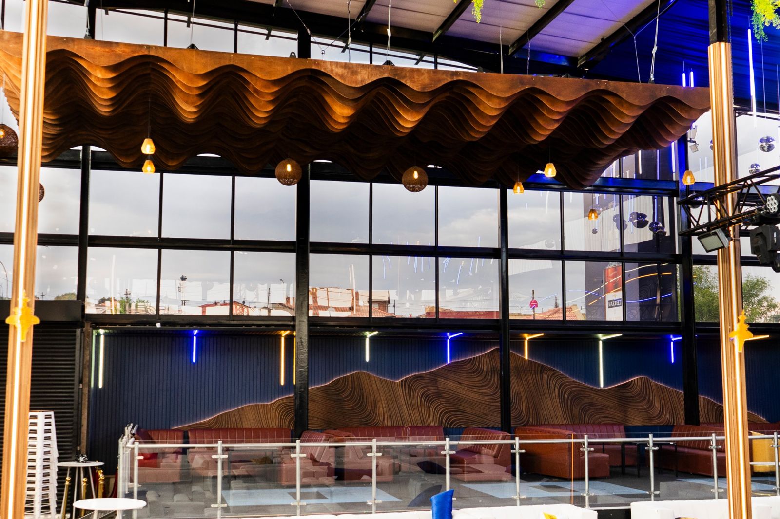 Parametric timber ceiling over a backlit mountain wall