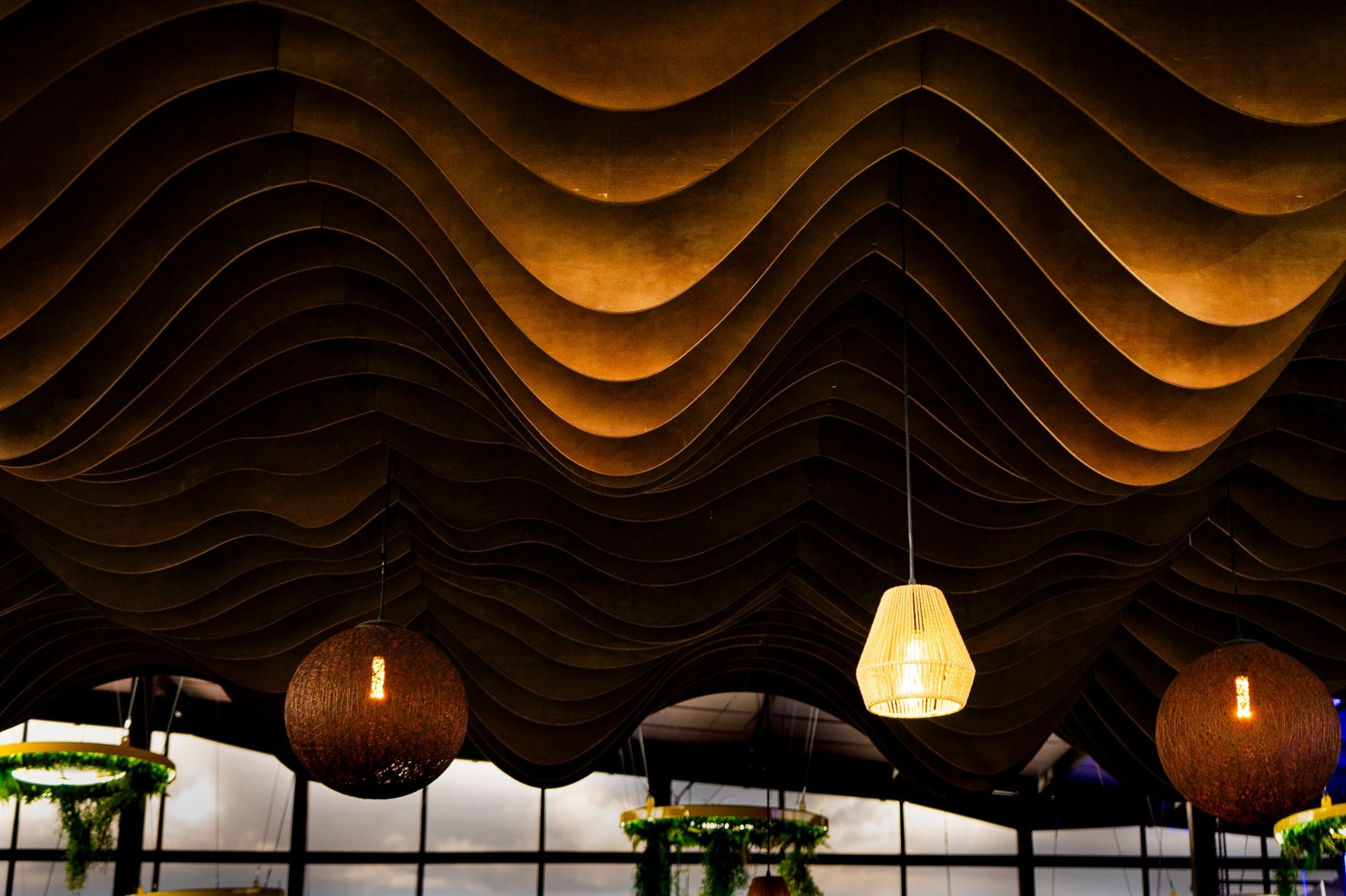 Parametric timber wave ceiling with woven pendant lights